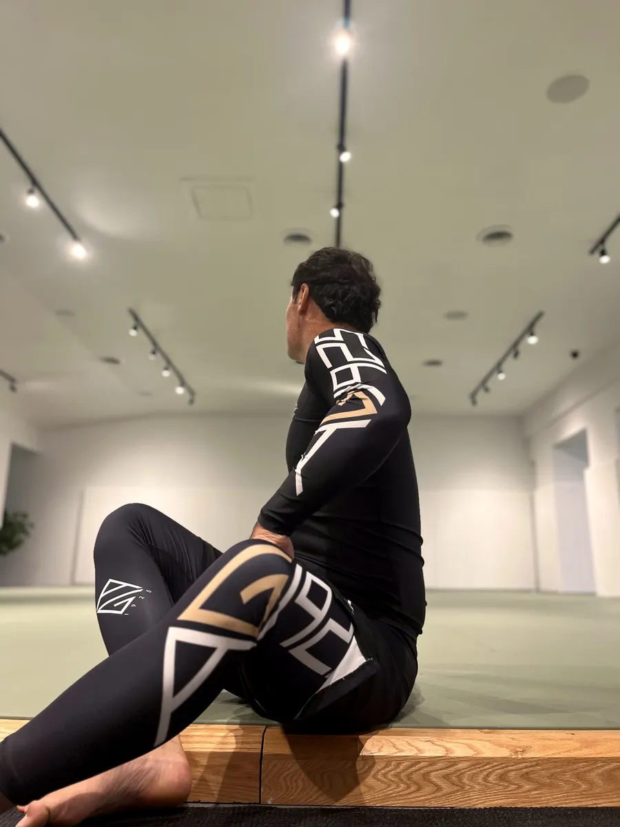 The AG1925 rashguard and spats, seated at the edge of the mat