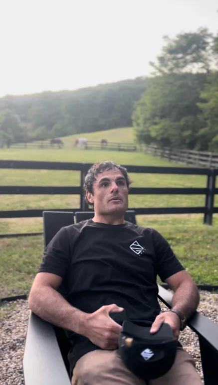Relaxing outdoors by a horse pasture in the AG1925 tee and cap
