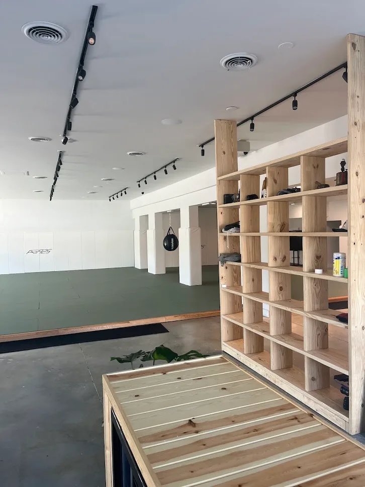 The academy mats seen past the wooden shelves by the entrance